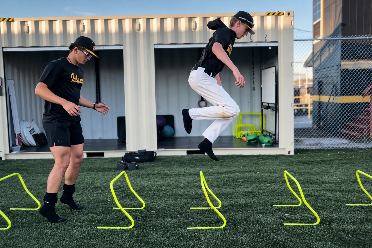 Athlete jumping yellow hurdles in front of the open FLXPOD