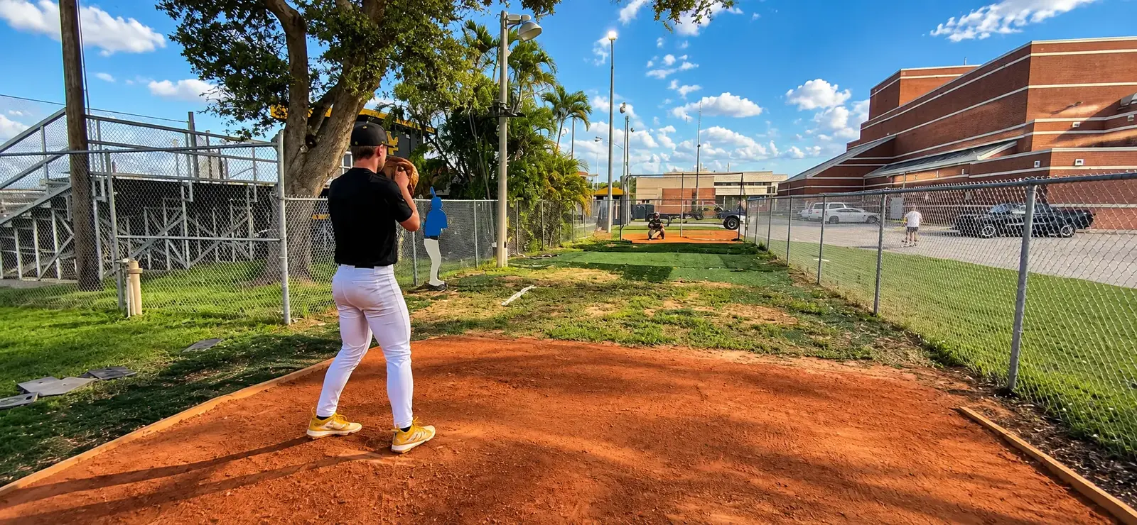 Tree-lined unused ground beside the Merritt Island High School baseball facility before the FLXPOD and turf were installed