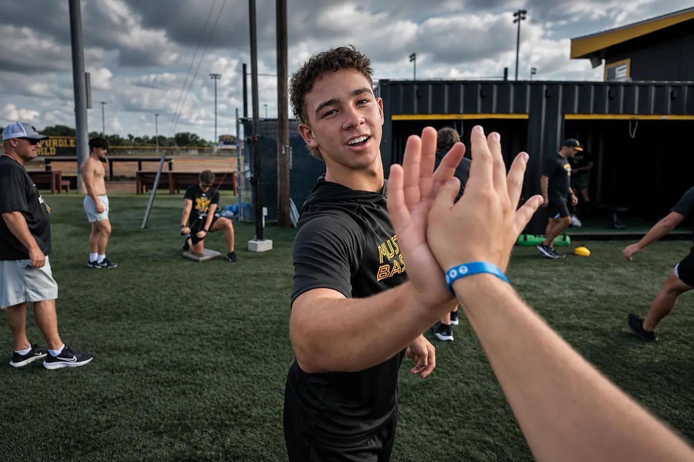 Athlete and coach sharing a high-five in front of the FLXPOD
